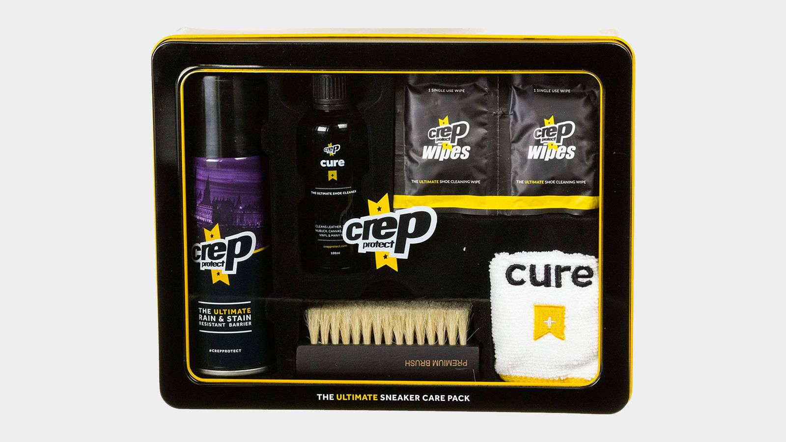 Crep Protect Ultimate product image of a black metal tin containing Cure shoe cleaning products plus a white cloth.