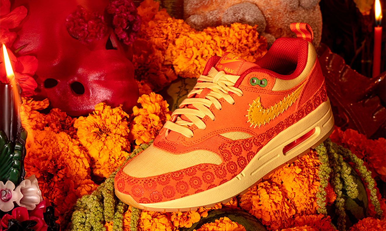 Nike Air Max 1 "Somos Familia" product image of an orange and cream suede sneaker featuring a Cempasúchil-inspired pattern.
