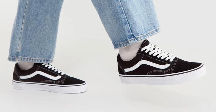Best Vans shoes Old Skool product image of a pair of black and white sneakers on feet.