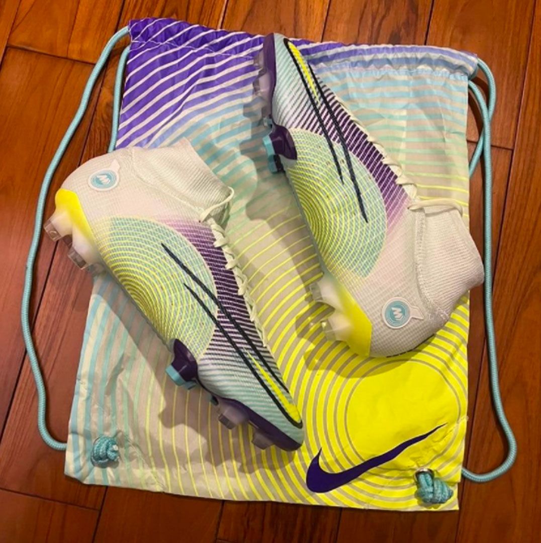 Nike Mercurial Dream Speed 5 in-hand image of a pair of green, yellow, and purple football boots with the bag.