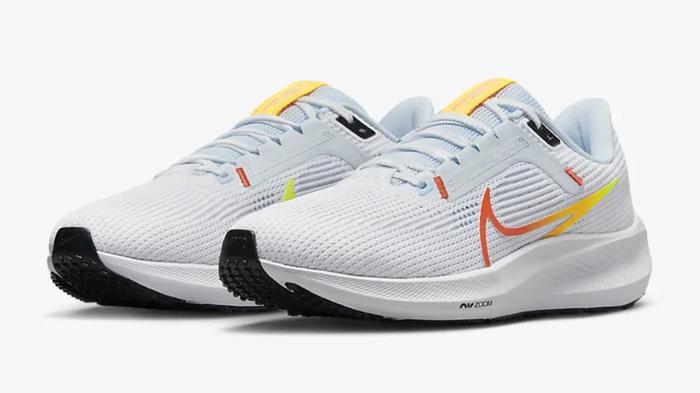 Nike vs Jordan sizing - Nike Pegasus 40 product image of white running shoes featuring yellow and orange Swooshes.