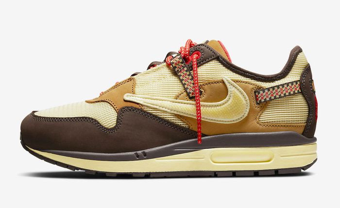 Travis Scott x Nike Air Max 1 “Baroque Brown” product image of a golden mesh and dark brown suede sneaker.