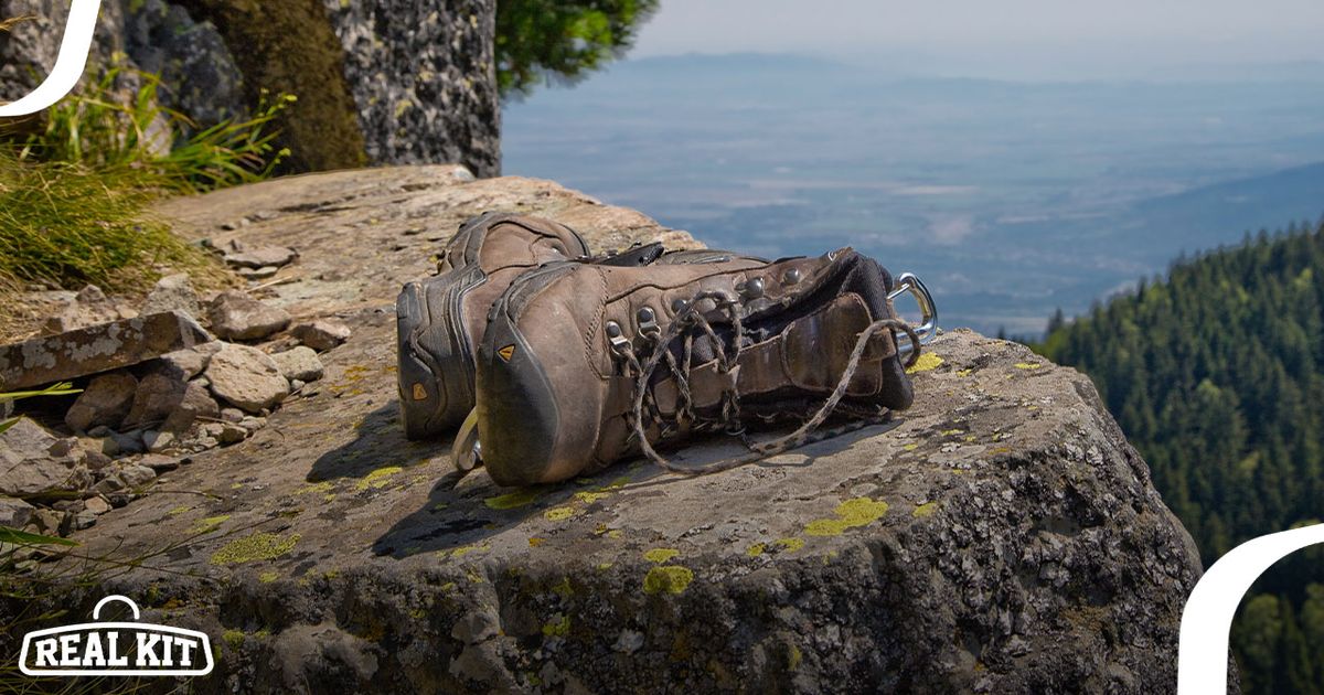 A pair of brown hiking boots laying on the edge of a rocky cliff.