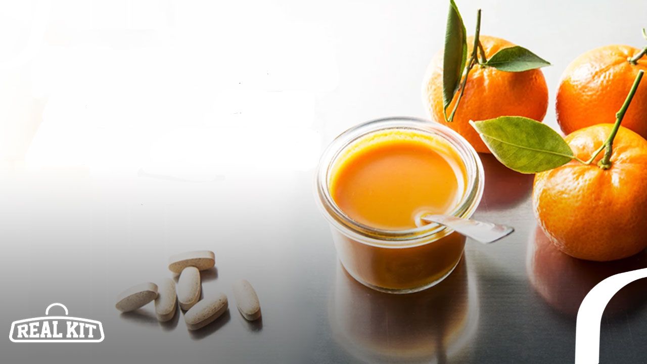 Image of light brown bitter orange capsules next to three oranges and juice.
