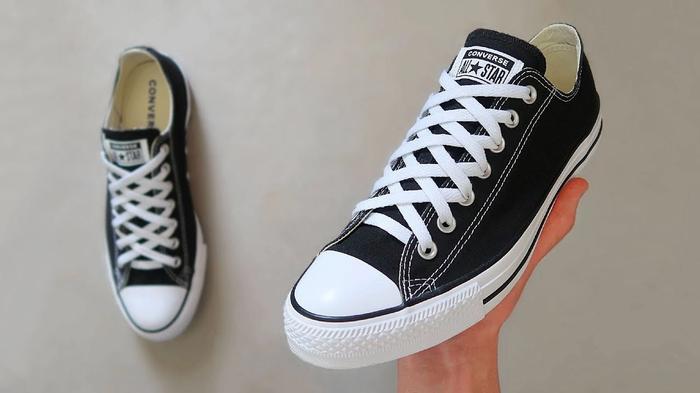 Converse product image of black sneakers with white, crisscrossing laces.