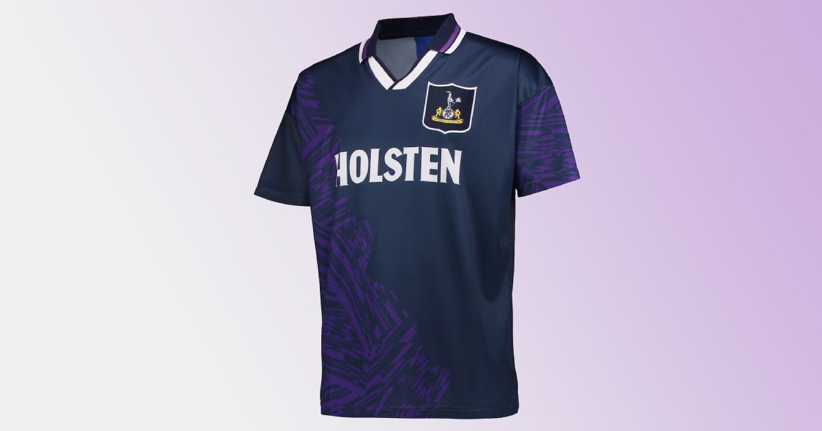 A retro Tottenham Hotspur replica away shirt in navy with a unique purple design across the front and sleeve and a white trimmed collar.