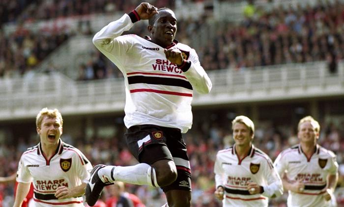 Best Manchester United kits Umbro 1998/99 image of Yorke celebrating in a white shirt with black and red details.