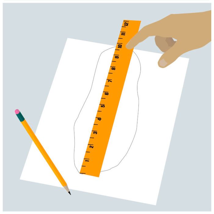 Image of someone measuring their foot outline with an orange ruler.