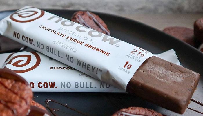 Best vegan protein bars Now Cow product image of a white packaged chocolate fudge brownie protein bar.