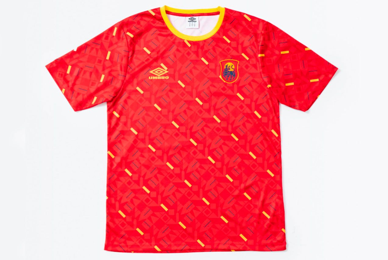 The Nations' Collection by Umbro product image of a red retro Spain shirt with a yellow geometric pattern all over.