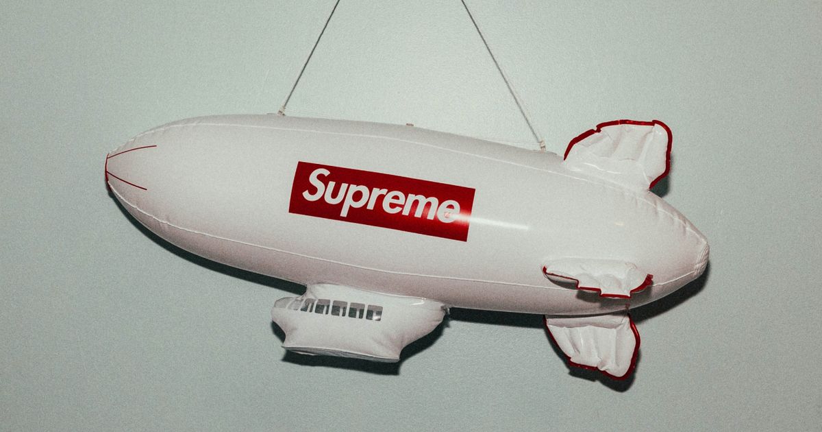 A white blimp model with the Supreme box logo in red on the side.