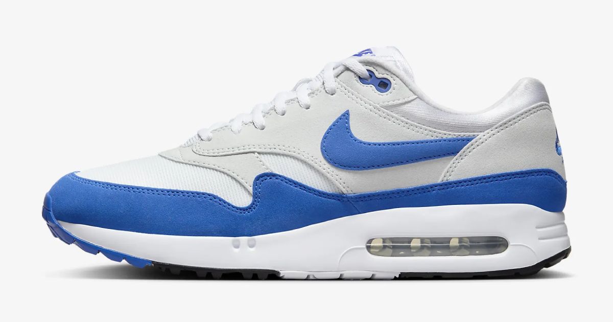 A white, gray, and blue Nike Air Max 1 Golf Shoe on a light gray background .