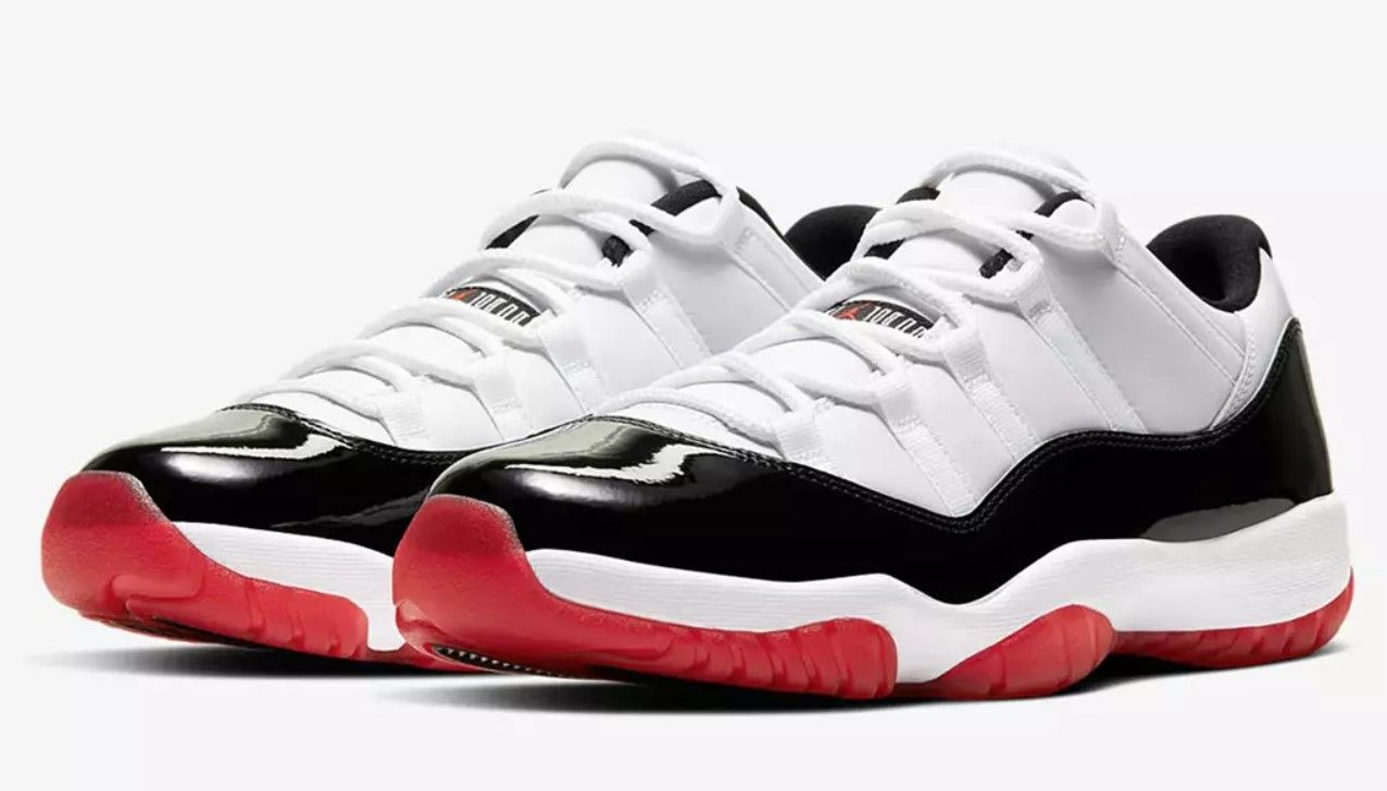 Air Jordan 11 "Concord Bred" product image of a pair of white sneakers with black and red accents.