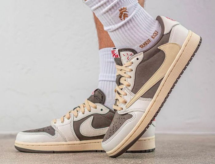 Latest Air Jordan news Travis Scott x Air Jordan 1 Low "Reverse Mocha" product image of a sail and brown suede pair of sneakers with reverse Swooshes.