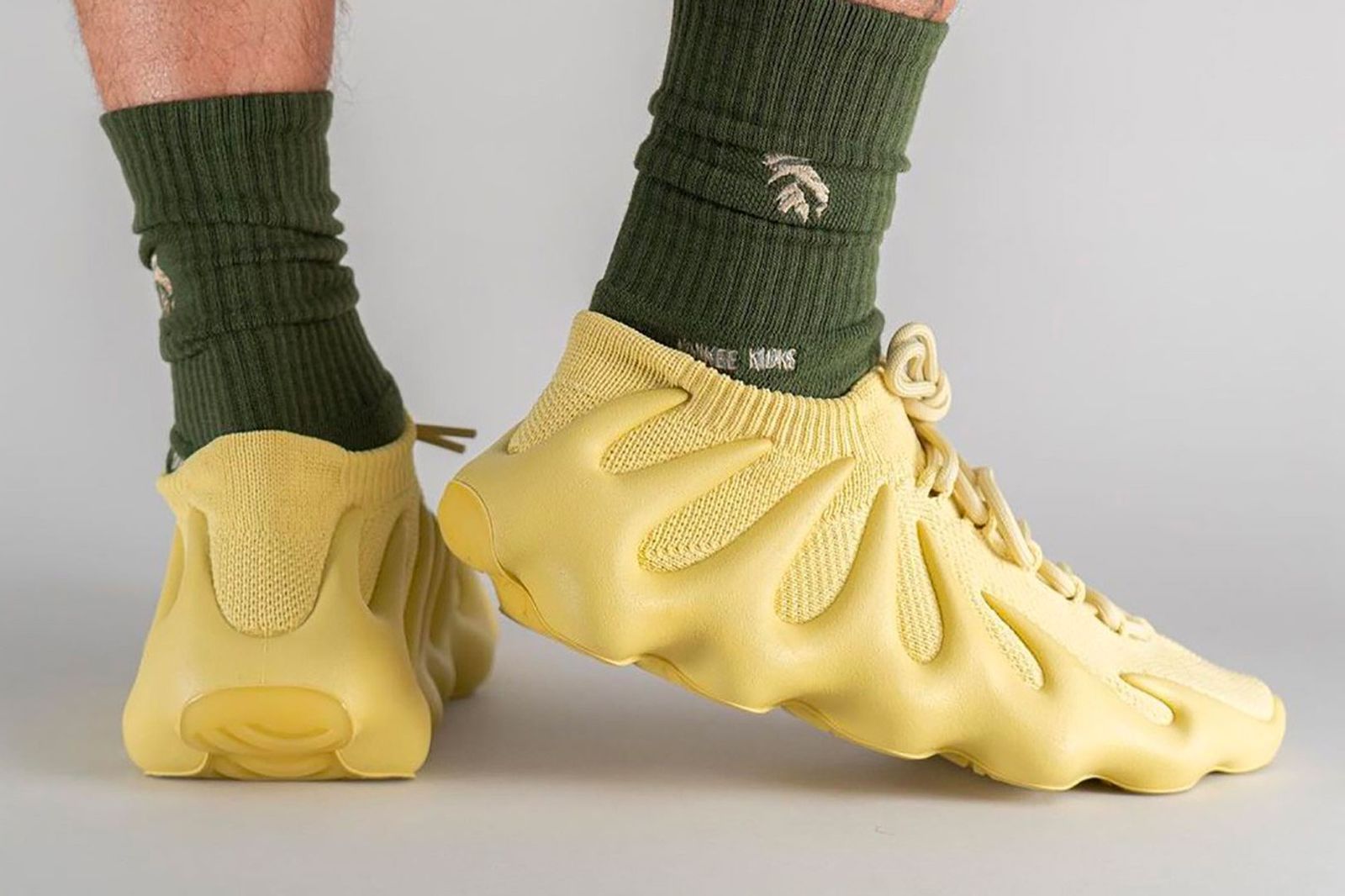 adidas Yeezy 450 "Sulfur" on-foot image of yellow PrimeKnit sneakers.