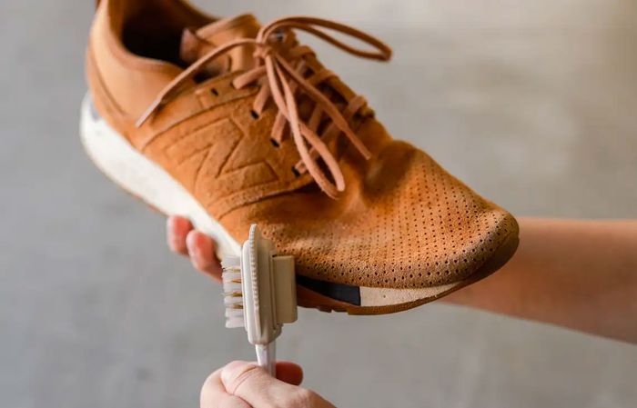 Image of a soft brush used to clean brown suede New Balance sneakers.