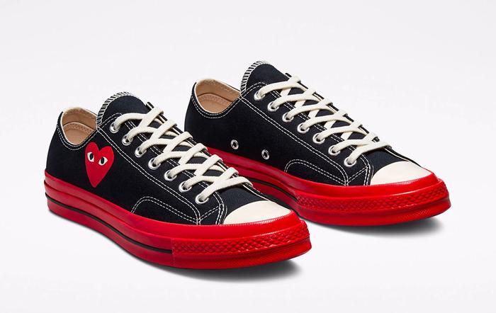Best Converse COMME des GARÇONS PLAY Chuck 70 product image of a pair of black canvas sneakers with red midsoles and a heart stitched on the sides.