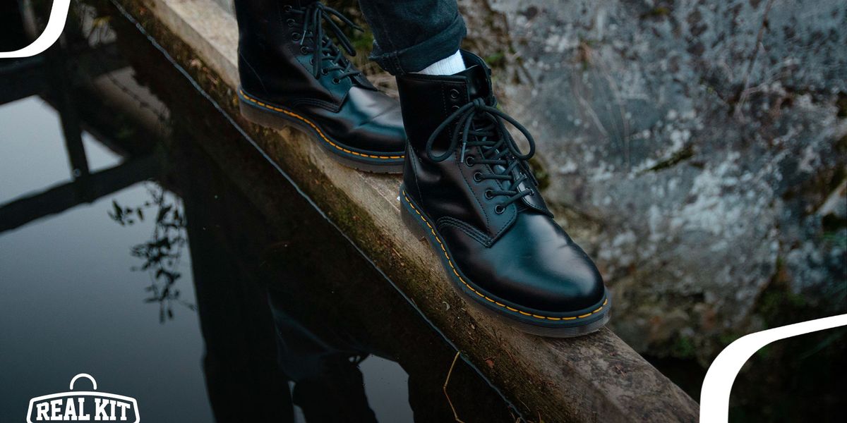 Image of a pair of black leather Doc Martens boots on feet.