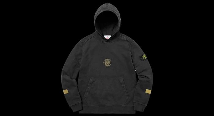Best Supreme collabs Supreme x Stone Island Hooded Sweatshirt product image of a black jumper with a golden Supreme x Stone Island logo in the centre.