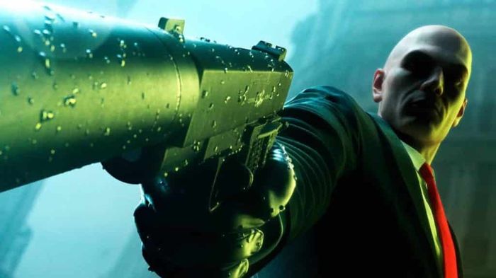 Agent 47 holding a silenced pistol in promotional art for Hitman 3.