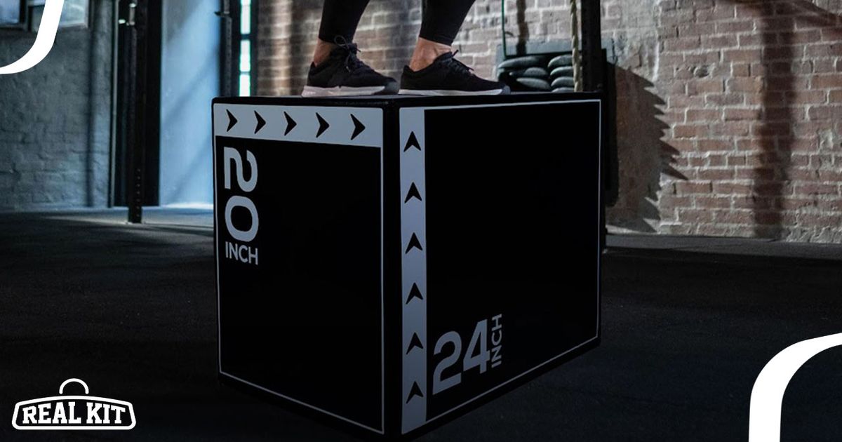 A black plyo box with height and width in white on the sides and someone in black shoes standing on top.