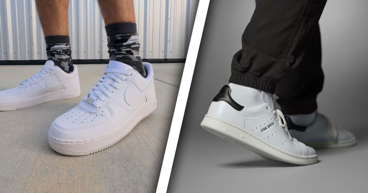 Someone in gray and black camo socks wearing all-white Air Force 1s on one side of a white line. On the other, someone in a pair of white adidas Stan Smiths with black heels.