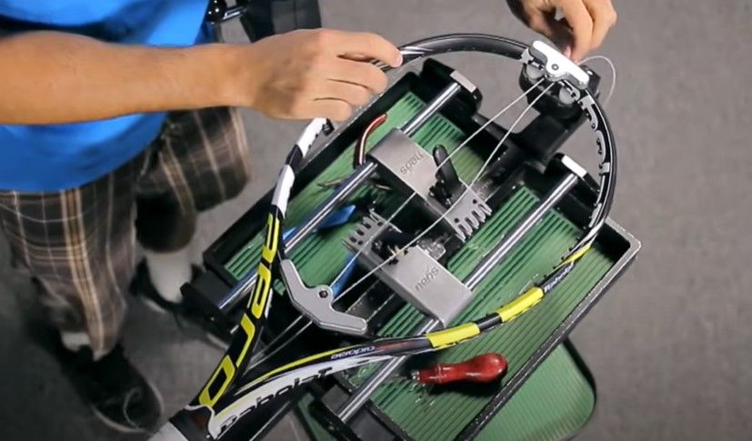 Image of a black, yellow, and white Babolat tennis racquet with two new strings threaded through the frame.