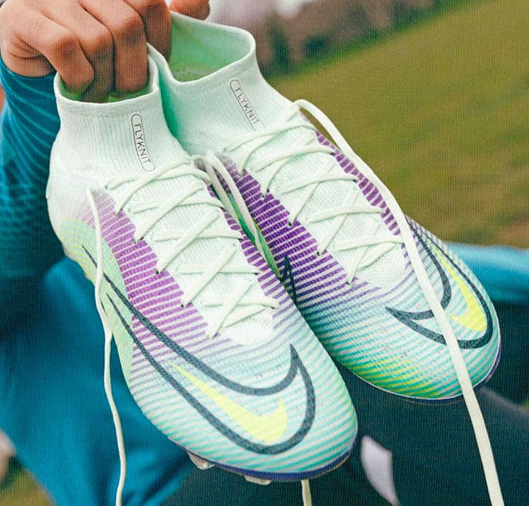 Nike Mercurial football boots in vivid green, white, and purple unlaced.
