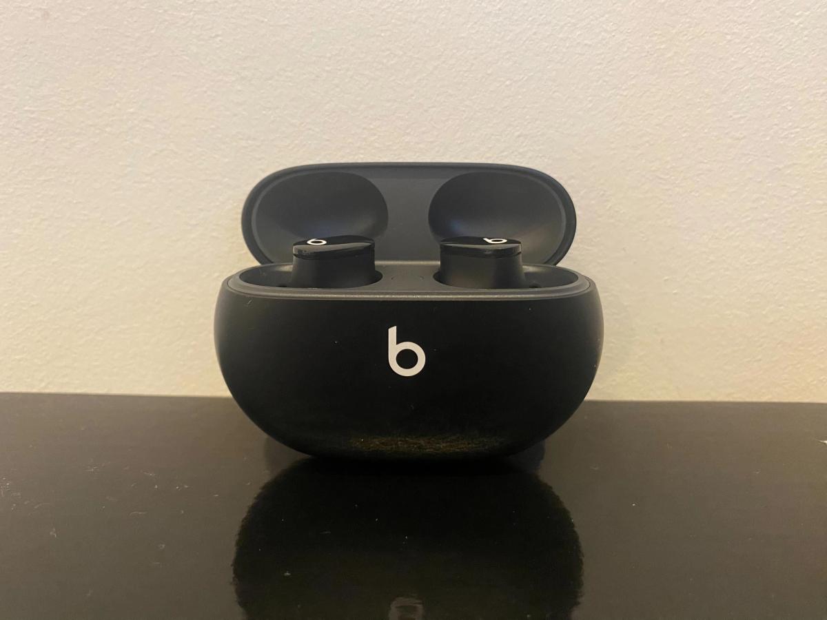 An image of black Beats Studio Buds inside a wireless charging case with white Beats branding on the front.