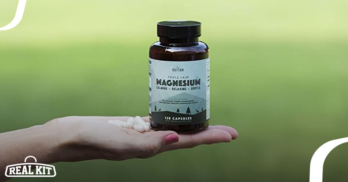 Image of a brown bottle with a black lid and green labelling on someone's hand next to white tablets.