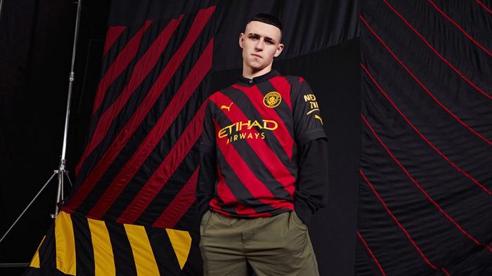 Manchester City PUMA away kit product image of a red and black diagonally striped kit.