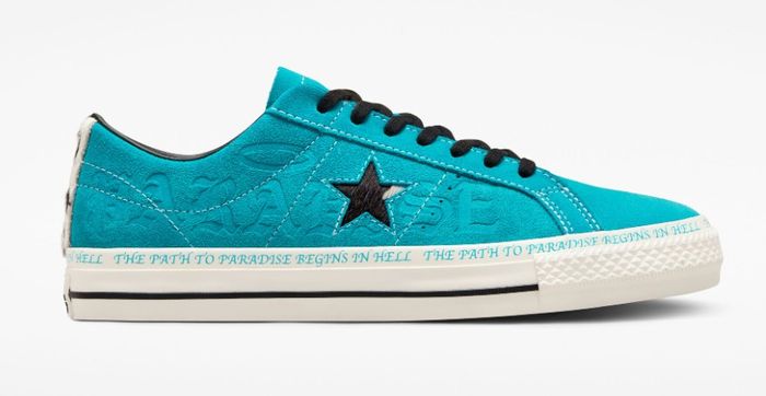 Converse product image of a single light blue suede sneaker with a black star on the side and a white midsole with the phrase "The Path To Paradise Begins In Hell" on the sides.