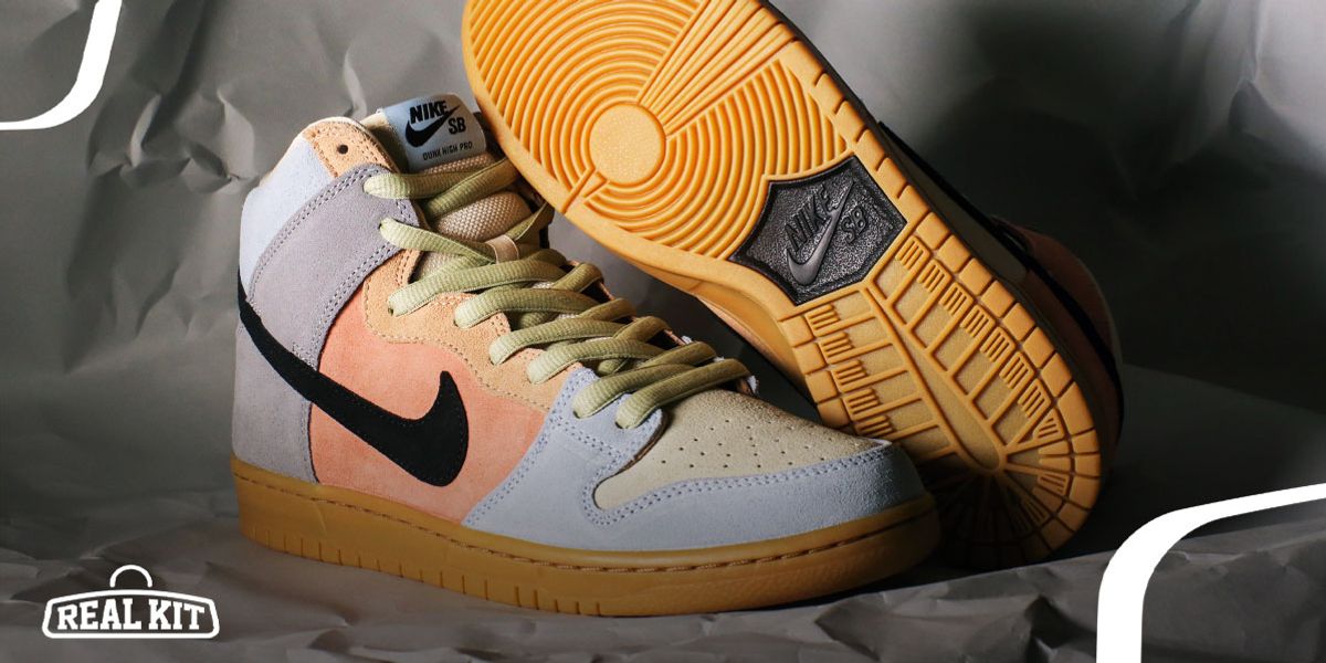 Image of a white, orange, and light purple pair of Nike SB Dunks featuring black Swooshes and gum soles.