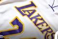 Image of a white Lakers jersey with purple and yellow lettering.