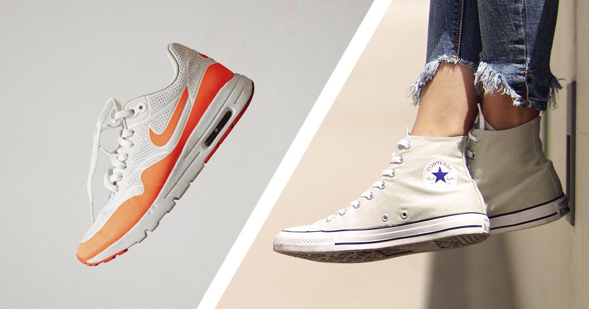 On one side of a diagonal white line, a singe grey Nike shoe with an orange mudguard and Swoosh along the sidewall. On the other side, someone wearing a pair of cream Converse high-tops.