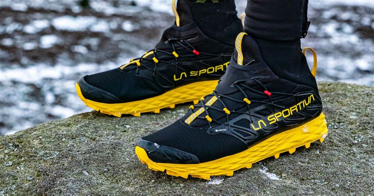 Someone wearing a pair of rugged black and yellow winter running shoes.