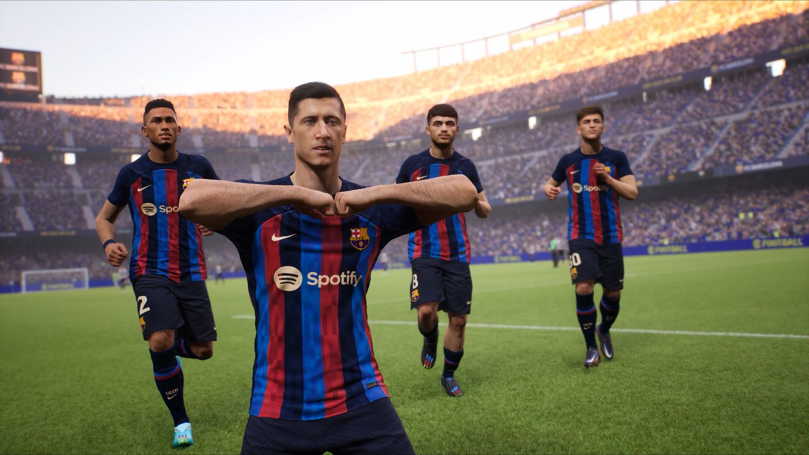 eFootball in-game image of Lewandowski celebrating wearing the red, blue, and navy striped Barcelona kit.