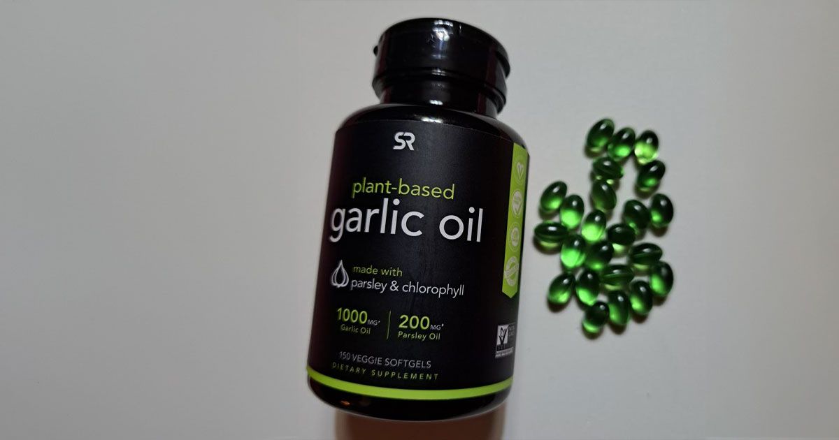 Image of a black container featuring green and white branding next to a collection of green garlic pills.