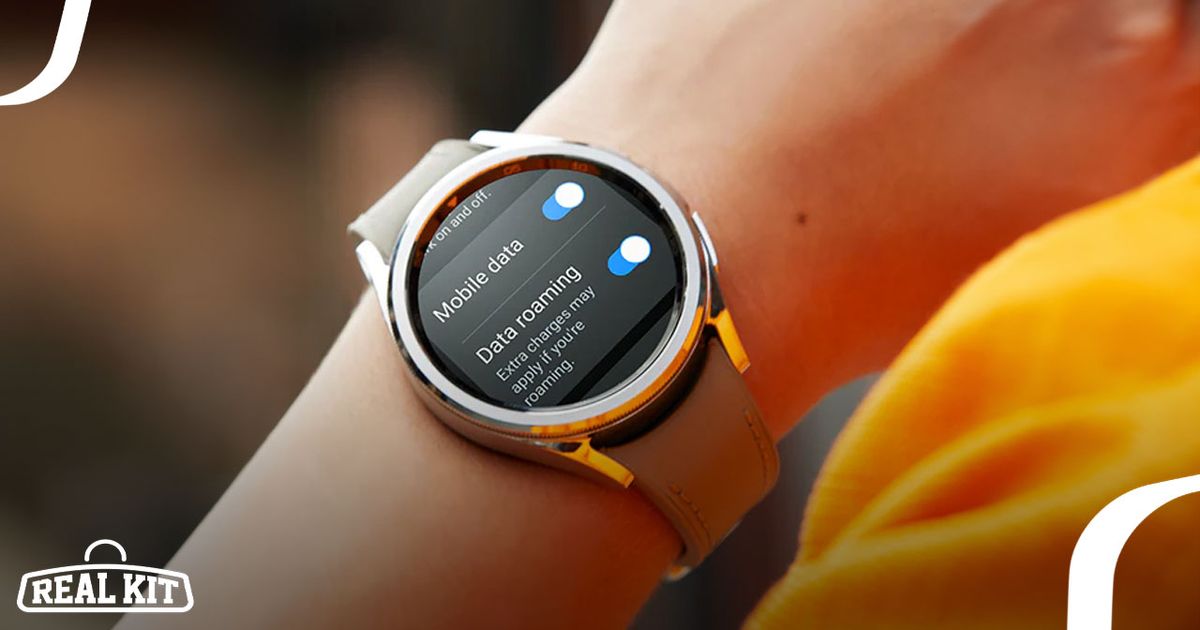 Someone in an orange top wearing a silver smartwatch with a black display and brown strap.