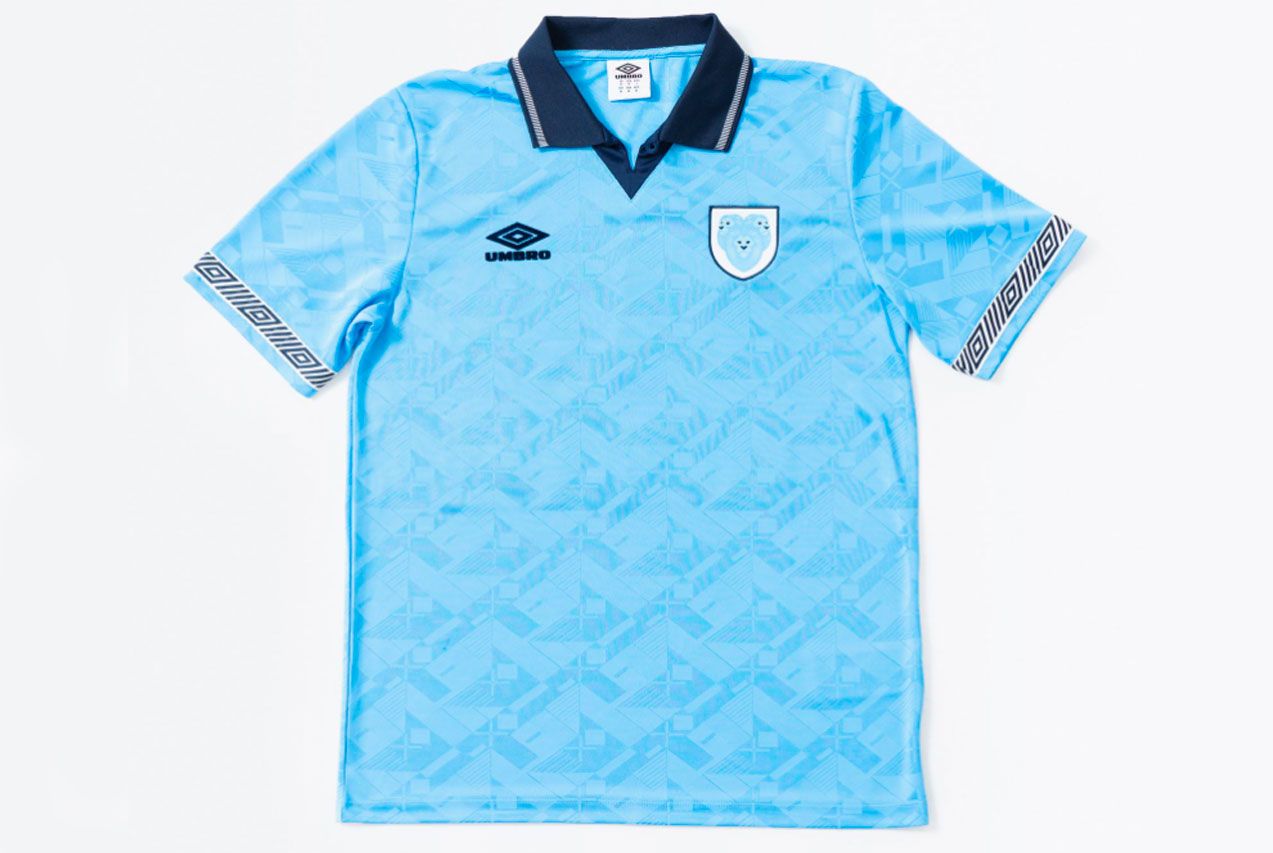 The Nations' Collection by Umbro product image of a light blue retro England shirt with a navy collar.