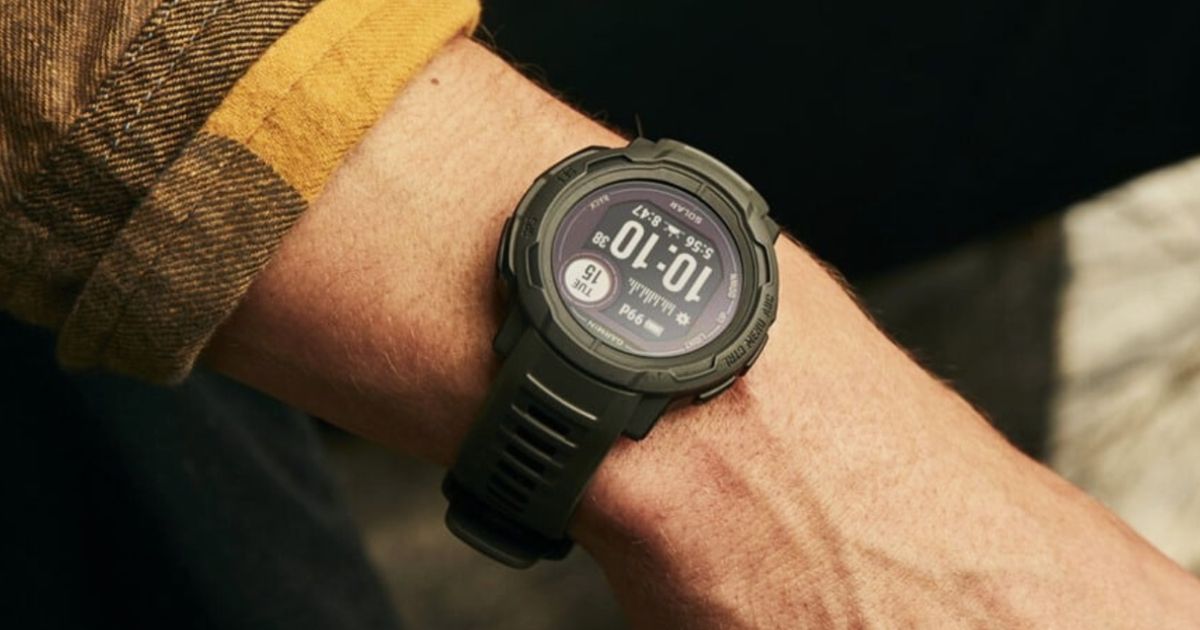 Image of someone in an orange and brown checkered shirt wearing a black Garmin smartwatch.