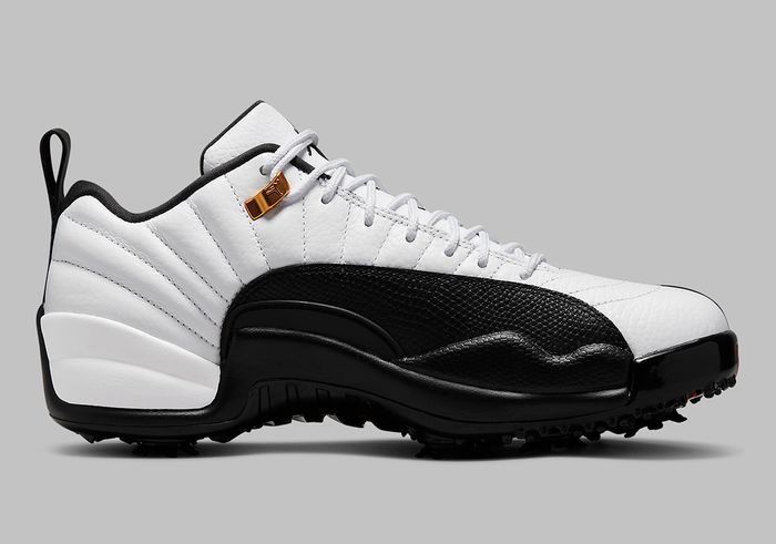 Air Jordan 12 Low Golf "Taxi" product image of a white sneaker with black overlays, gold accents, and spikes underfoot.