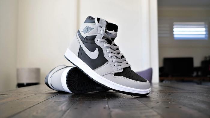 How to lace Jordan 1 - Air Jordan 1 image of black and grey shoes with white midsoles and grey laces.