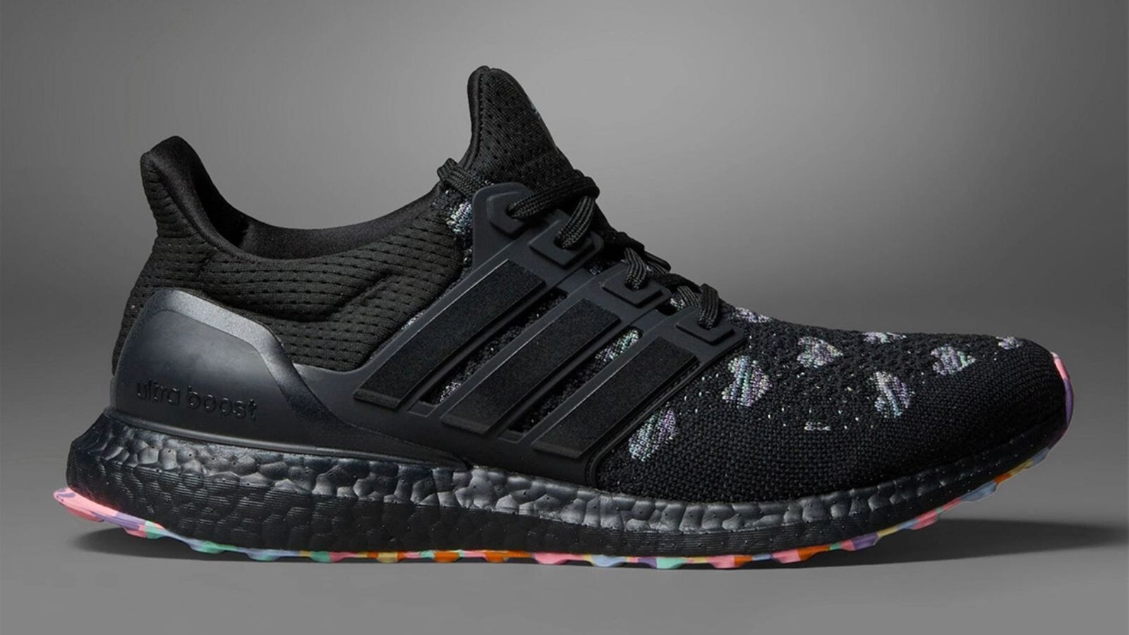 Best sneakers for Valentine's Day - adidas Ultraboost 1.0 "Valentine's Day" product image of a black sneaker with pastel colours underneath and White love hearts across the toebox.