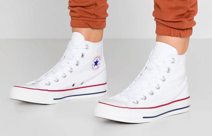 Converse product image of a pair of white high-tops on feet.