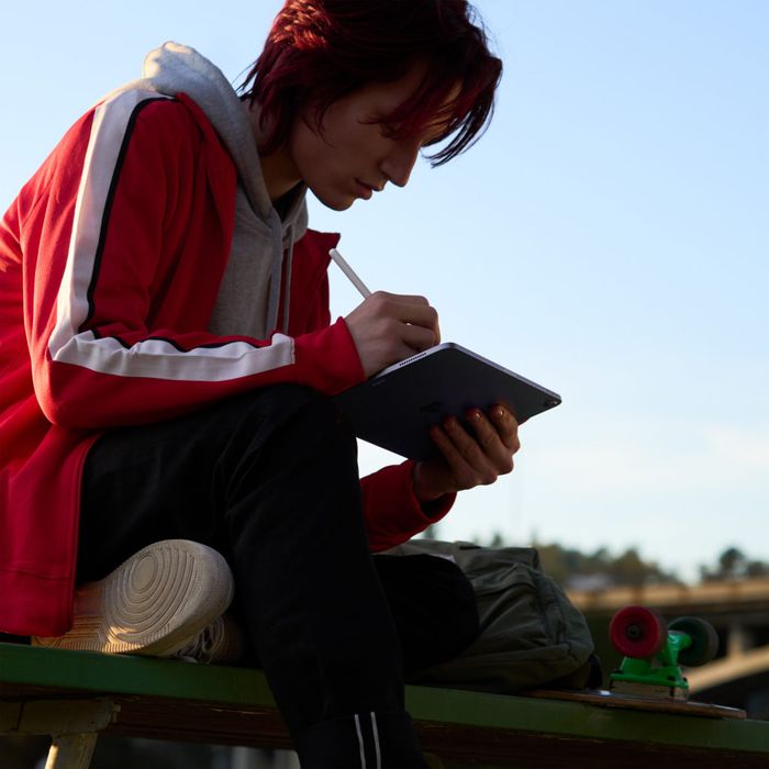 Person sitting on a bench using an Apple Pencil