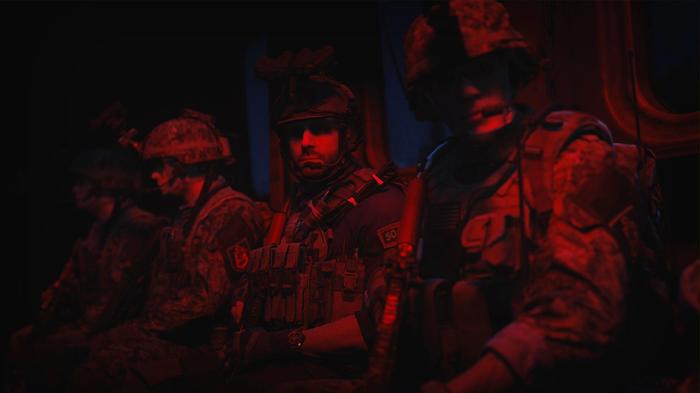 Soldiers bathed in red light, waiting to start a mission
