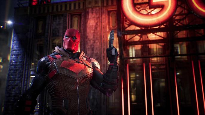 Red Hood with an orange light shining on the wall behind him - Gotham Knights local co-op