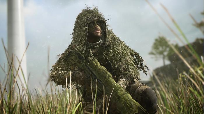 A heavily-camouflaged soldier kneels in the grass - Modern Warfare 2 slow download
